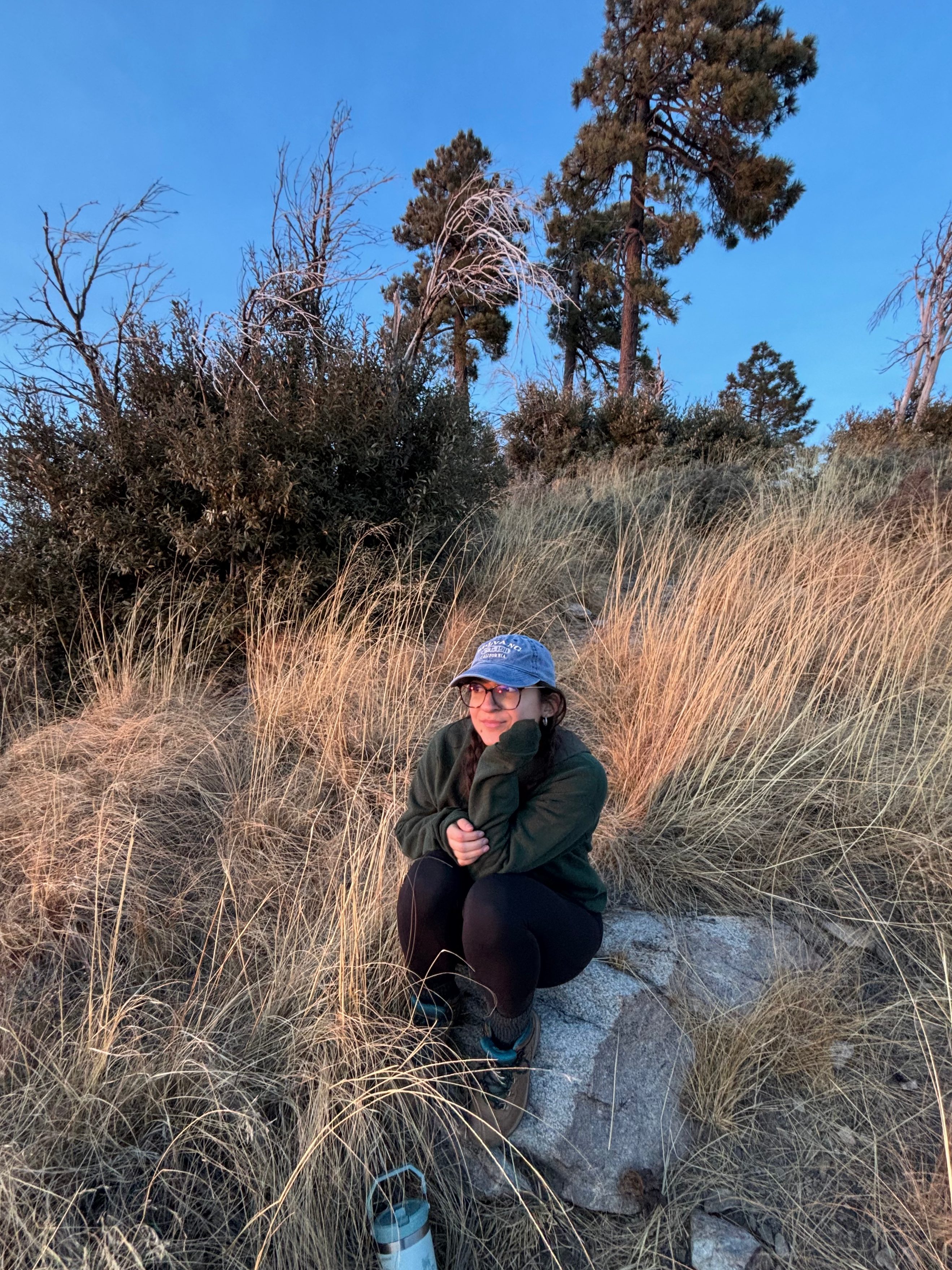 Maria Cruz sitting on a mountain.